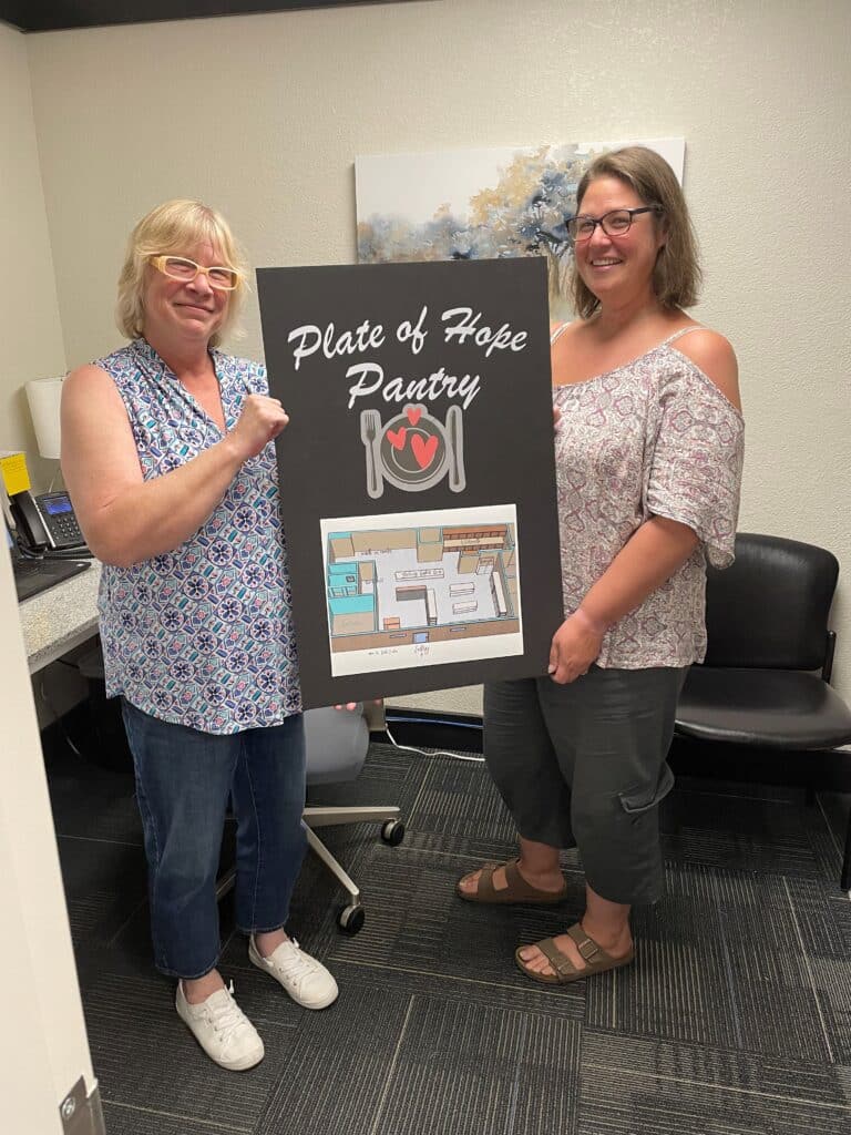 Picture of Rayetta and Kelley Holding a Plate of Hope Pantry Sign